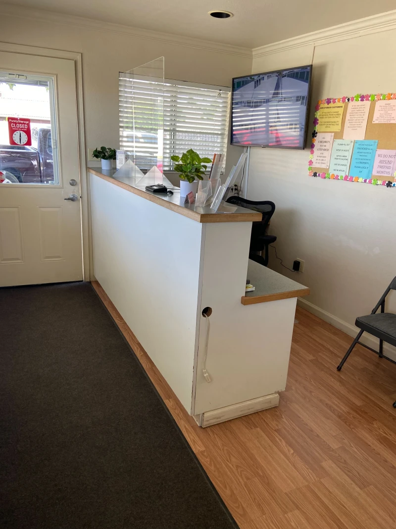 white front reception desk and tv with security cameras