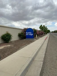 street and sidewalk with purely storage logo sign and tan self storage building