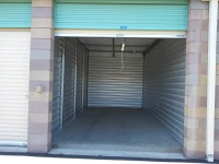 open storage unit with green door and cinder block walls