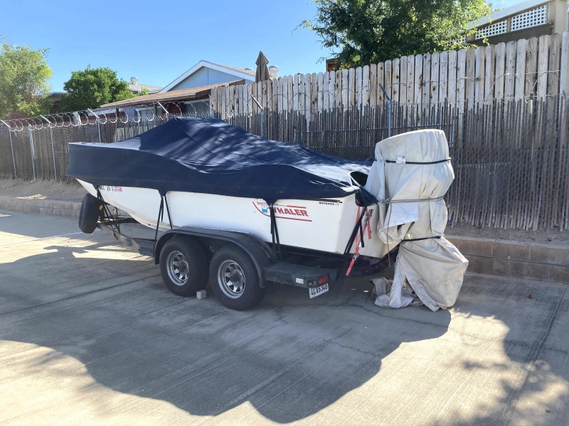 boston whaler boat parked along fence inside storage facility
