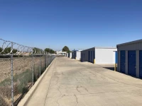 back chain link fence with razor wire surrounding a storage facility in bakersfield