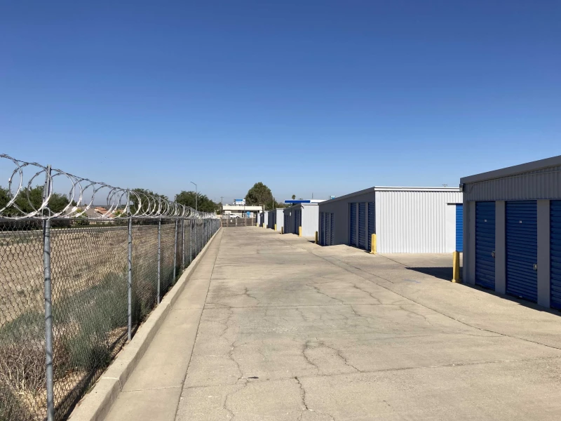 back chain link fence with razor wire surrounding a storage facility in bakersfield